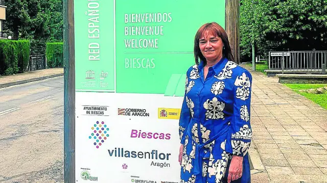 Nuria Pargada junto al cartel de la Reserva donde se ha colocado el de Villas en Flor.