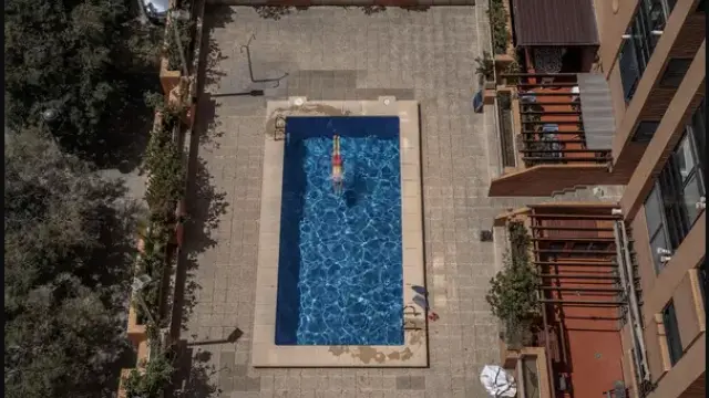 Una persona se baña en una piscina comunitaria.
