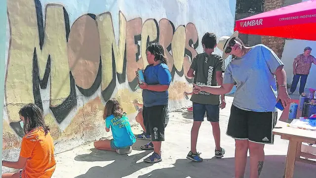 Erika, a la derecha, contó con la colaboración de los niños de Perdiguera para pintar su mural.