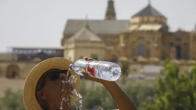Una turista combate con agua fresca las altas temperaturas de Córdoba.