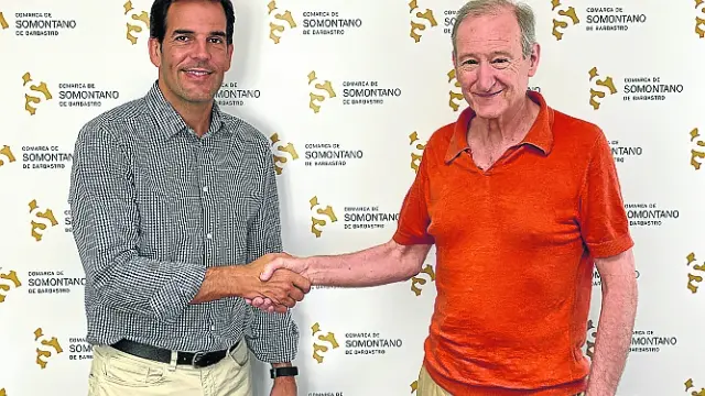 Daniel Gracia y Nacho Alcalde estrechan sus manos tras firmar el acuerdo de colaboración.