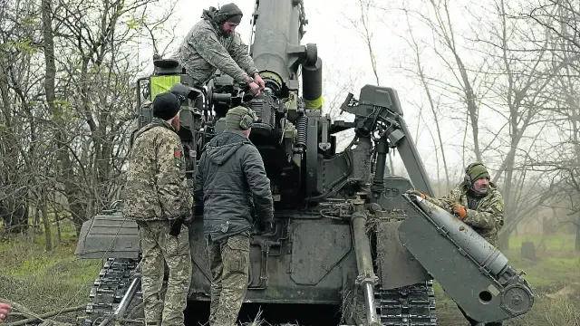 Soldados ucranianos cargan su pieza de artillería.