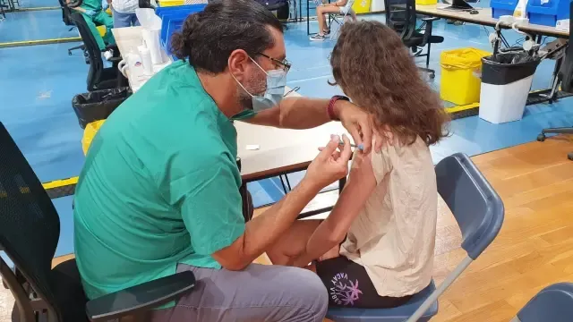 Un enfermero vacuna a una niña.