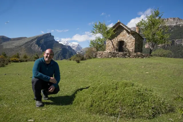 El informador turístico de Aínsa comarcal, Santiago Nerín, posa ante una vista el Cañón de Añisclo desde el pueblo de Vió