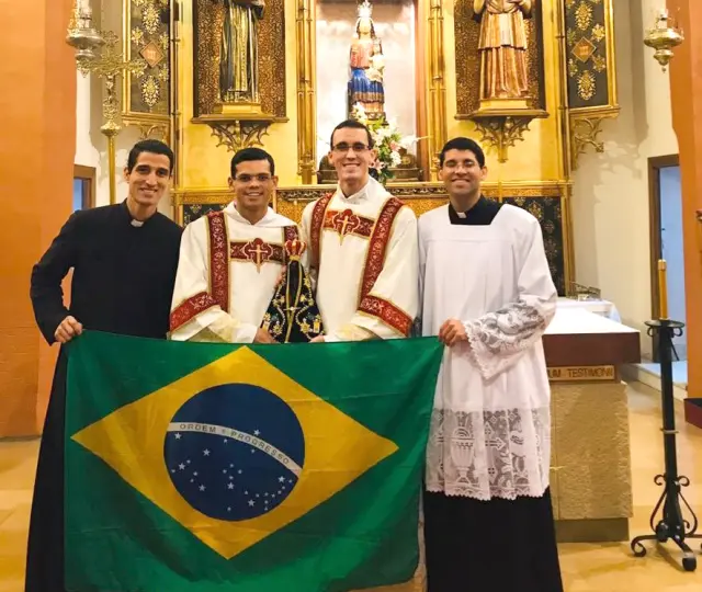 Monjes del centro de formación, algunos procedentes de Brasil, con la bandera