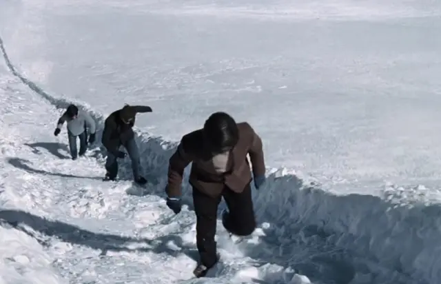 Los protagonistas caminan encima de las rampas, cubiertas de nieve.