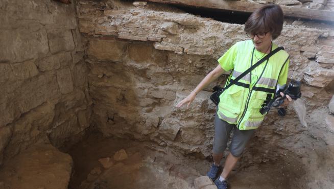 La arqueóloga Julia Justes señala el molde de fundición de campanas, en la “casa del perrero”.