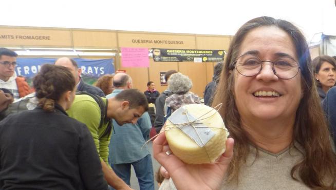 Elena Uzcategui muestra uno de sus quesos en la pasada edición de la Feria de Otoño de Biescas.