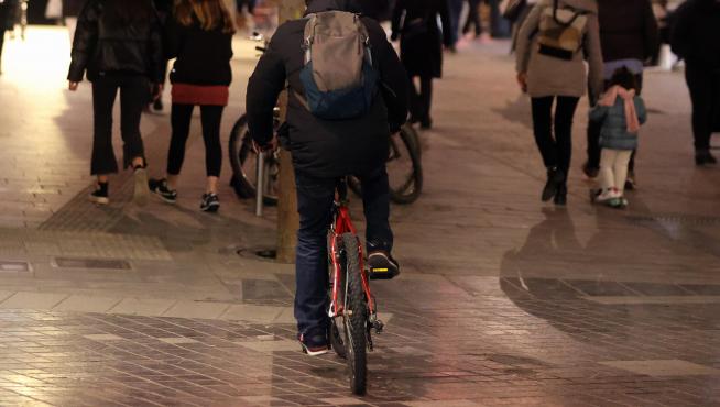 Un joven circulando en bicicleta por el centro de la capital oscense este lunes.