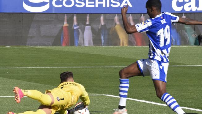 Álvaro Fernández se lanza a por el balón ante la amenaza de Isak en el Huesca-Real Sociedad.