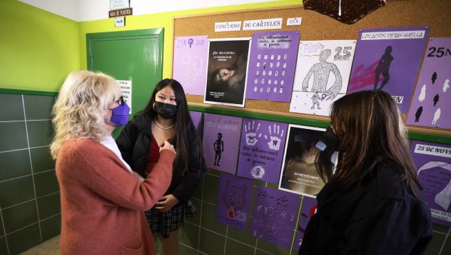 Silvia Salazar conversa con dos alumnas sobre los carteles.