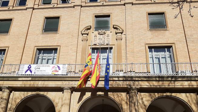 Imagen de la Subdelegación del Gobierno en Huesca con sus banderas a media asta.