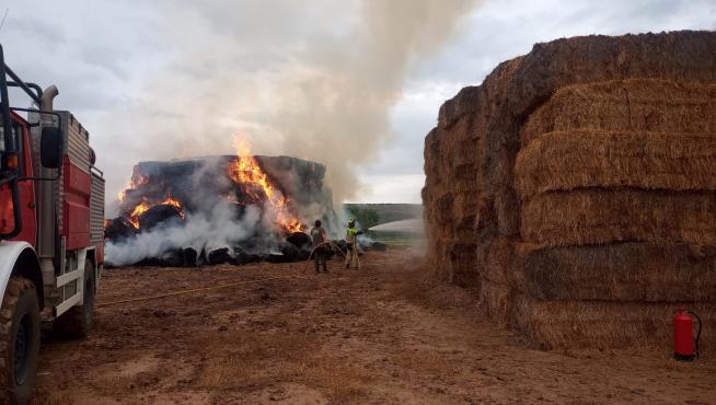 Trabajos de extinción del incendio de pacas de paja en una granja de Chalamera.