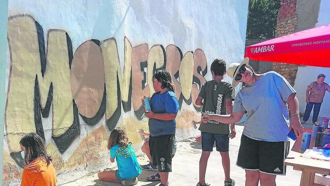 Erika, a la derecha, contó con la colaboración de los niños de Perdiguera para pintar su mural.