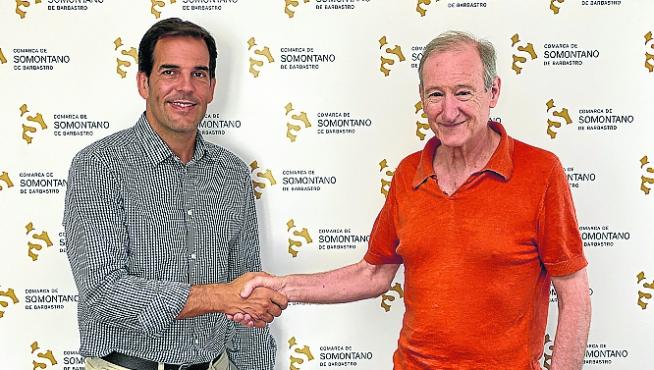 Daniel Gracia y Nacho Alcalde estrechan sus manos tras firmar el acuerdo de colaboración.