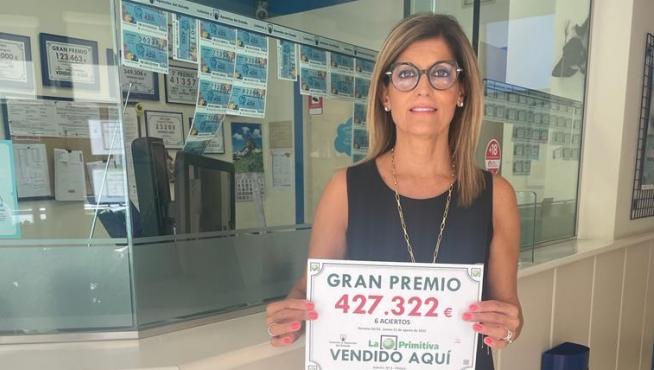 Una encargada de la administración posa con el premio.