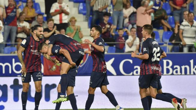 Los jugadores del Huesca celebran el tanto de Juan Carlos, que dio la victoria en el último partido contra el Málaga.