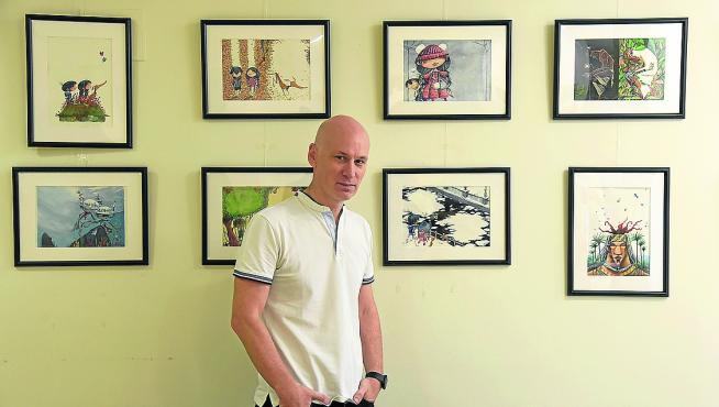 David Guirao junto a algunas de las ilustraciones que expone en la Biblioteca Pública de Huesca.
