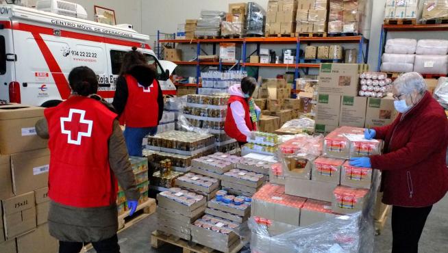 Voluntarios de Cruz Roja Huesca organizan alimentos para las 429 familias de la provincia que los disfrutarán.