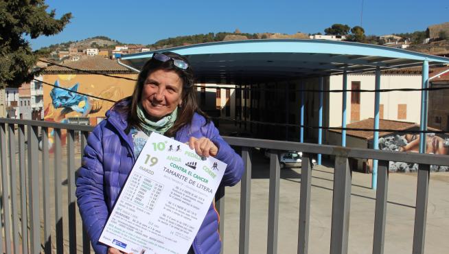 Mercé Miranda frente a la carpa municipal en Tamarite de Litera con el cartel de la actividad.