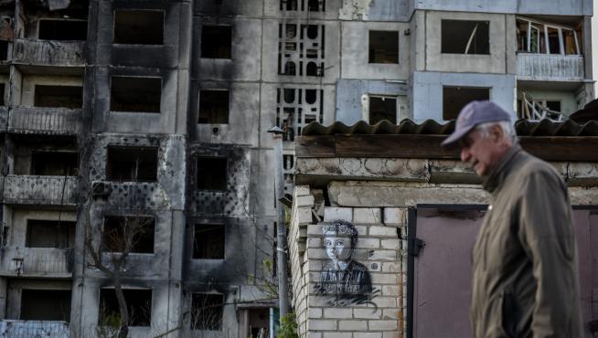 En la ciudad ucraniana de Borodyanka, un hombre pasa junto a una obra del artista Christian Guemy.
