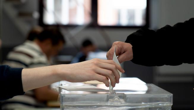 Un votante deposita su papeleta en la urna este domingo en un colegio electoral de Teruel.