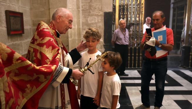 Dos niños reciben la bendición del Santo Cristo de los Milagros, esta mañana en la Catedral de Huesca.