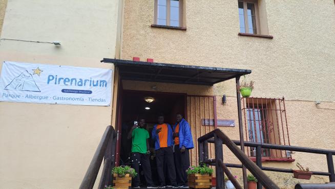 Tres jóvenes inmigrantes en las puertas del albergue Pirenarium de Sabiñánigo, esta mañana.