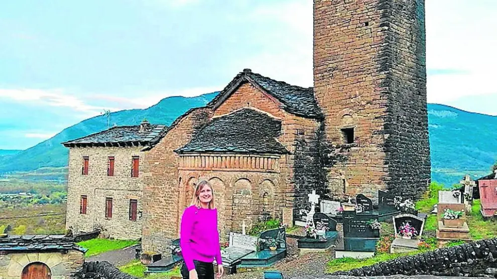 Mónica Ara, directora de la oficina de Caja Rural de Aragón en Jaca junto a la iglesia de su pueblo: Oliván