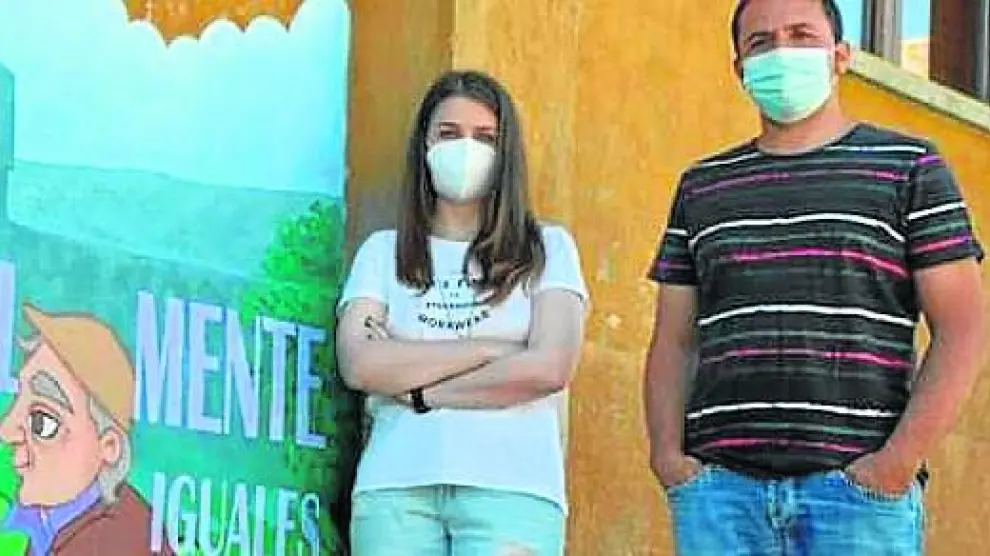 La artista María Salinas junto al alcalde de Lascuarre, José Luis Lloret, junto al mural pintado en el casco urbano.