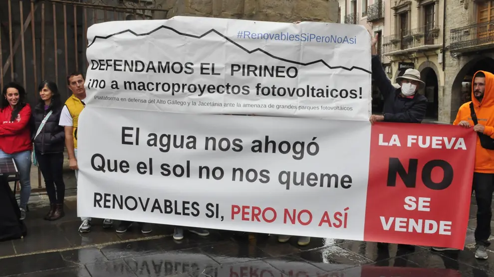 Representantes de las diferentes plataformas comarcales mostraron pancartas contra los macroparques solares a las puertas de la Catedral de Jaca.