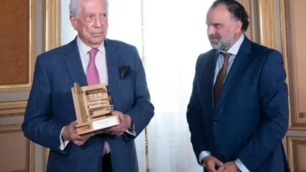 Vargas Llosa muestra el premio que le ha recibido de manos de Fernando de Yarza.