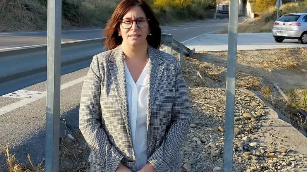 La alcaldesa de Tardienta, Miriam Ponsa, junto al cartel de entrada al pueblo.