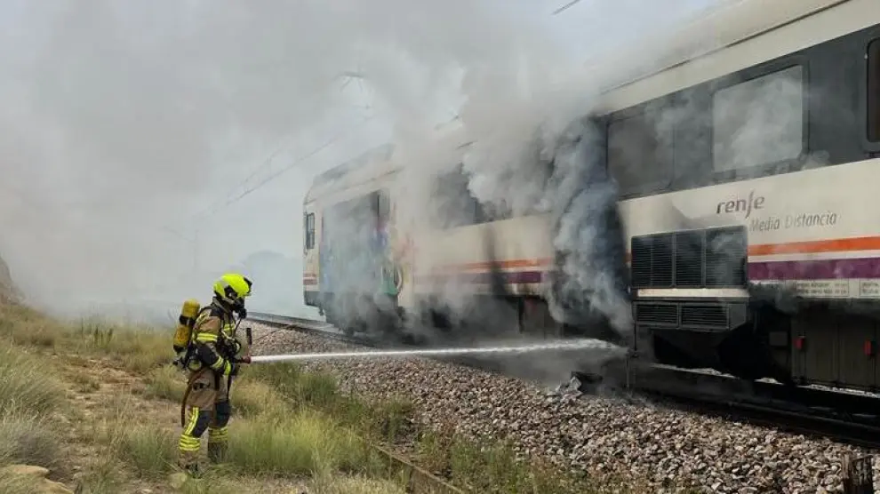 Labores de extinción del incendio en un tren de la línea Zaragoza-Lérida.