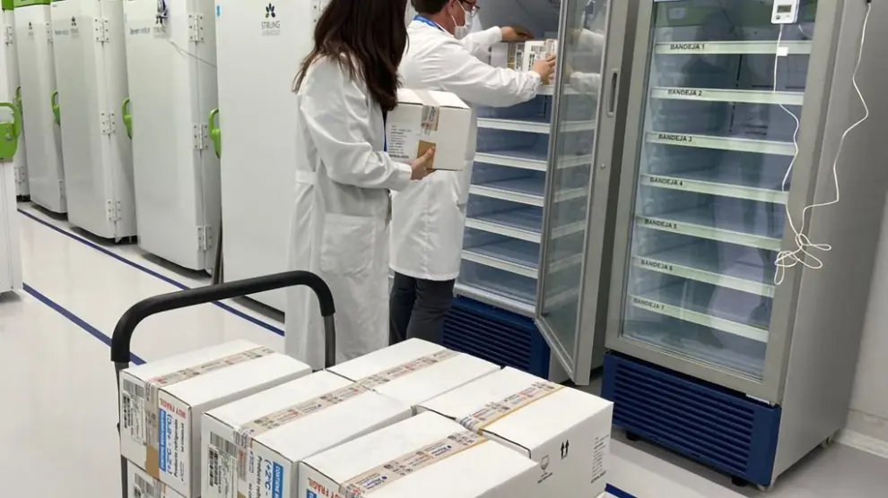 Dos técnicos meten en cámaras frigoríficas las vacunas de AstraZeneca distribuidas por el Ministerio de Sanidad.