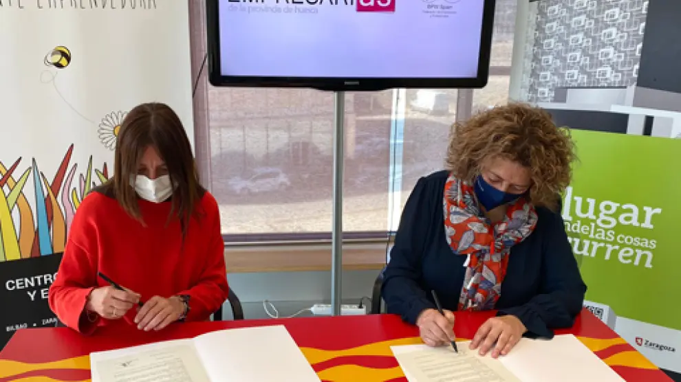 Carmen Fernández y Romy Piñeyroa firman el convenio entre ambas entidades.