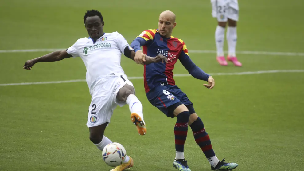 Sandro pelea con Djené por hacerse con el balón en el Huesca-Getafe.