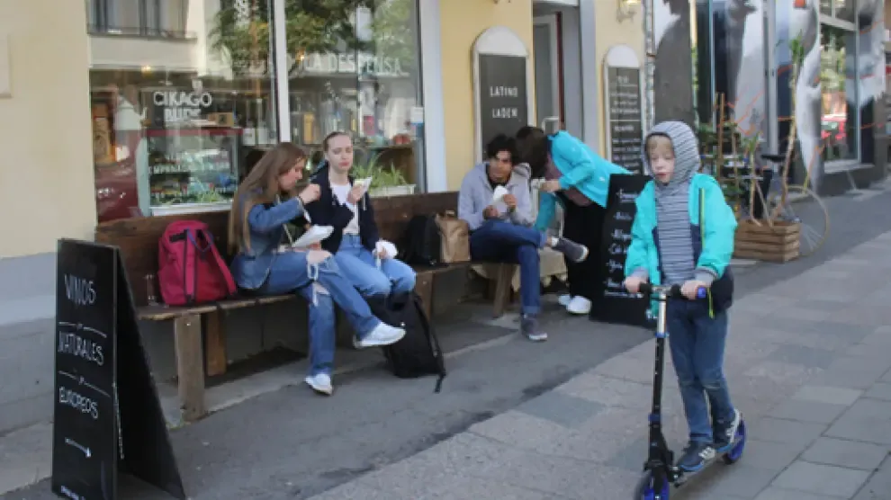 Clientes comiendo en el banco de una tienda de Berlín ahora que en el país se pide una PCR negativa para ocupar una terraza.