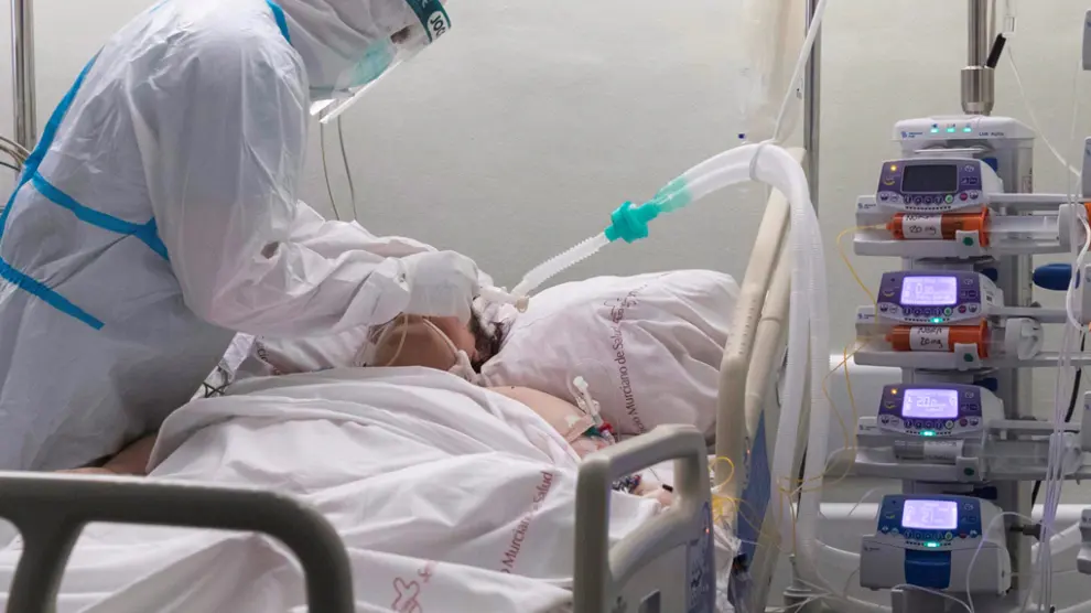 Un enfermero del hospital Morales Meseguer, de Murcia, atiende a un paciente ingresado por COVID-19 en la UCI