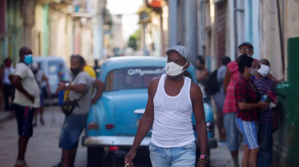 Un hombre camina por una calle con cubetas de huevos en La Habana.
