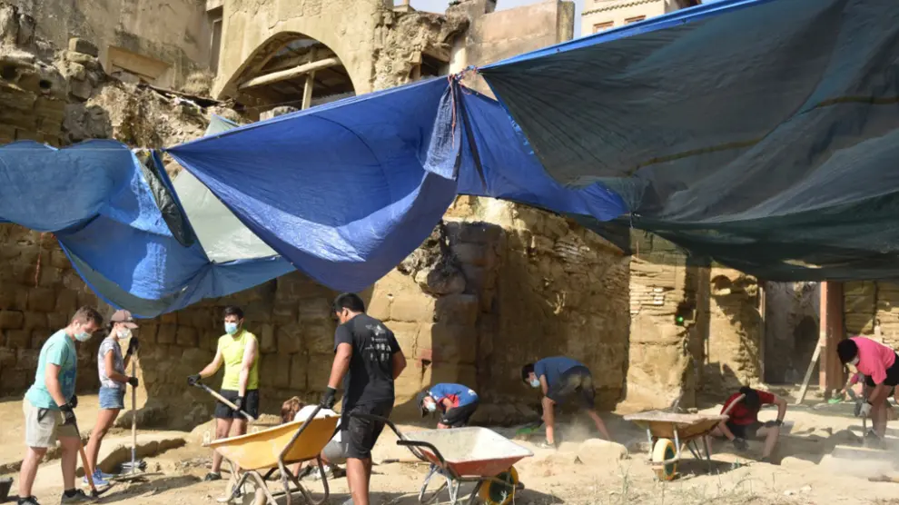 Jóvenes de un campo de trabajo impulsado por la Diócesis excavan en el entorno de la catedral de Huesca, donde se han hallado restos romanos, andalusíes y medievales