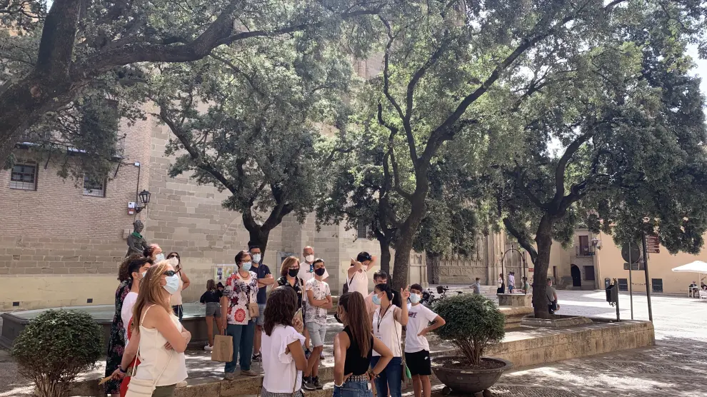 Grupo de turistas frente al Ayuntamiento de Huesca en una visita guiada a la ciudad