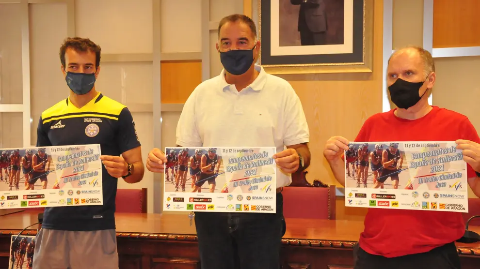 Carlos Lannes, Domingo Poveda y Míchel Galay, con el cartel de la competición, en el Salón de Ciento del Ayuntamiento de Jaca.