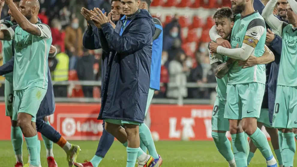 Los jugadores del Huesca, felices por la victoria, fueron a celebrar con los aficionados tras el partido.
