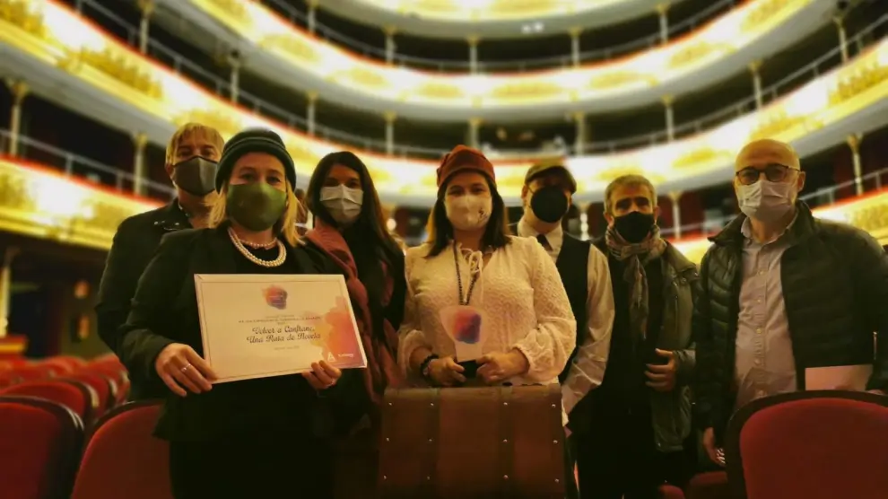 Representantes de Volver a Canfranc muestran el premio y el diploma recibido.