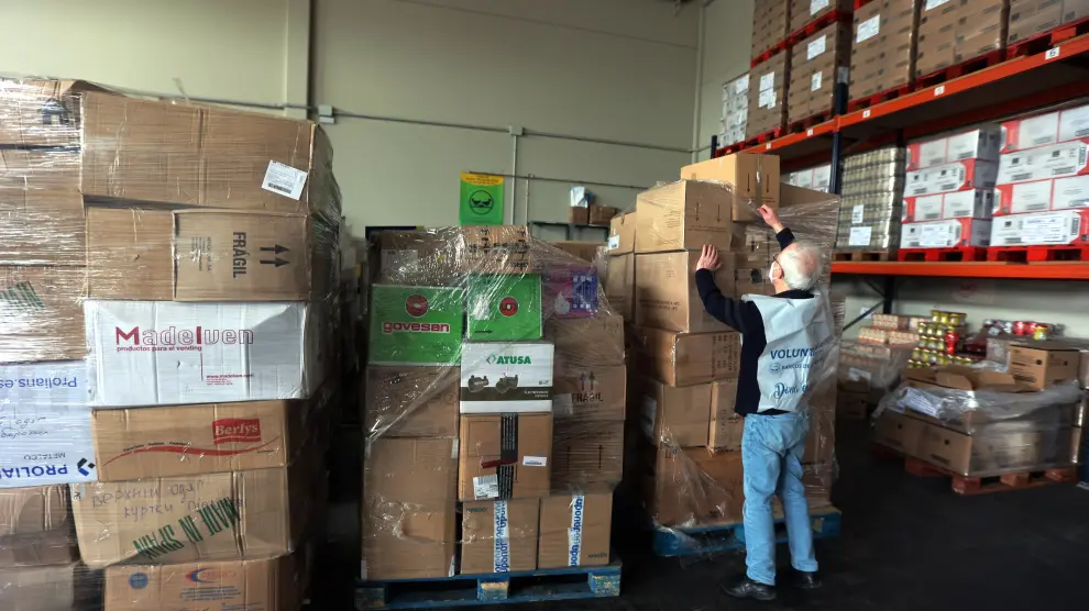 Un voluntario del Banco de Alimentos de Huesca clasifica algunas cajas de material en el almacén.