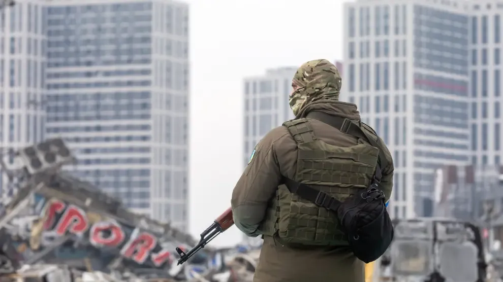 Un militar ucraniano junto a un centro comercial destruido en Kiev.