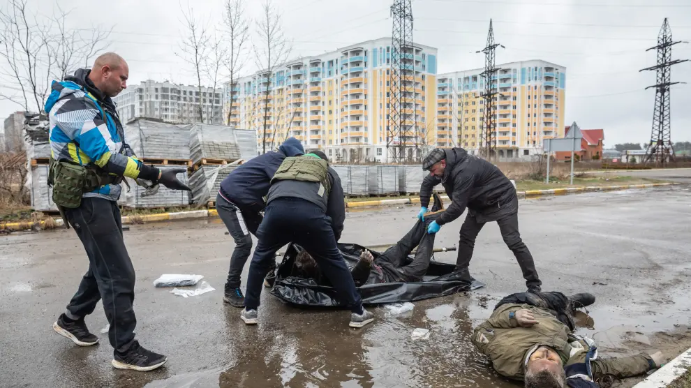 Personal civil retira uno de los muchos cuerpos hallados en las calles tras el abandono del ejército ruso en Bucha.