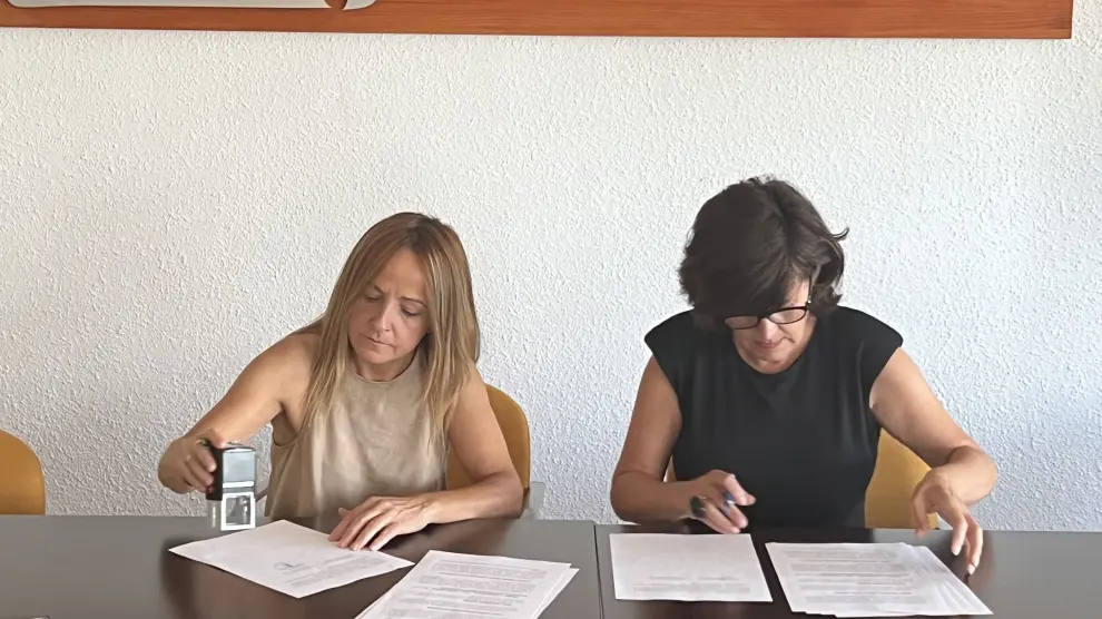 Firma del convenio entre Esperanza López y Lourdes Arruebo.