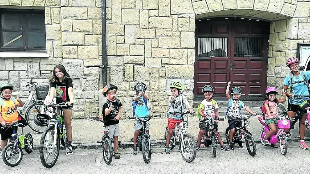 Un grupo de niños junto a sus monitoras, se disponen a salir a andar en bicicleta.